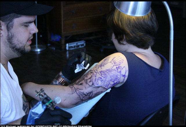 Tattoo artist working on lady